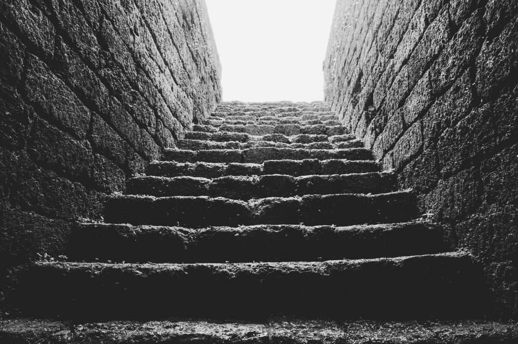 Low angle grayscale photo of empty brick stairs