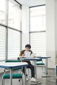 a man sitting while looking at his test papers