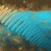 An abstract digital artwork featuring a golden and teal spiral-like structure set against a textured background of earthy browns and vibrant blues, with scattered specks and patches adding depth.